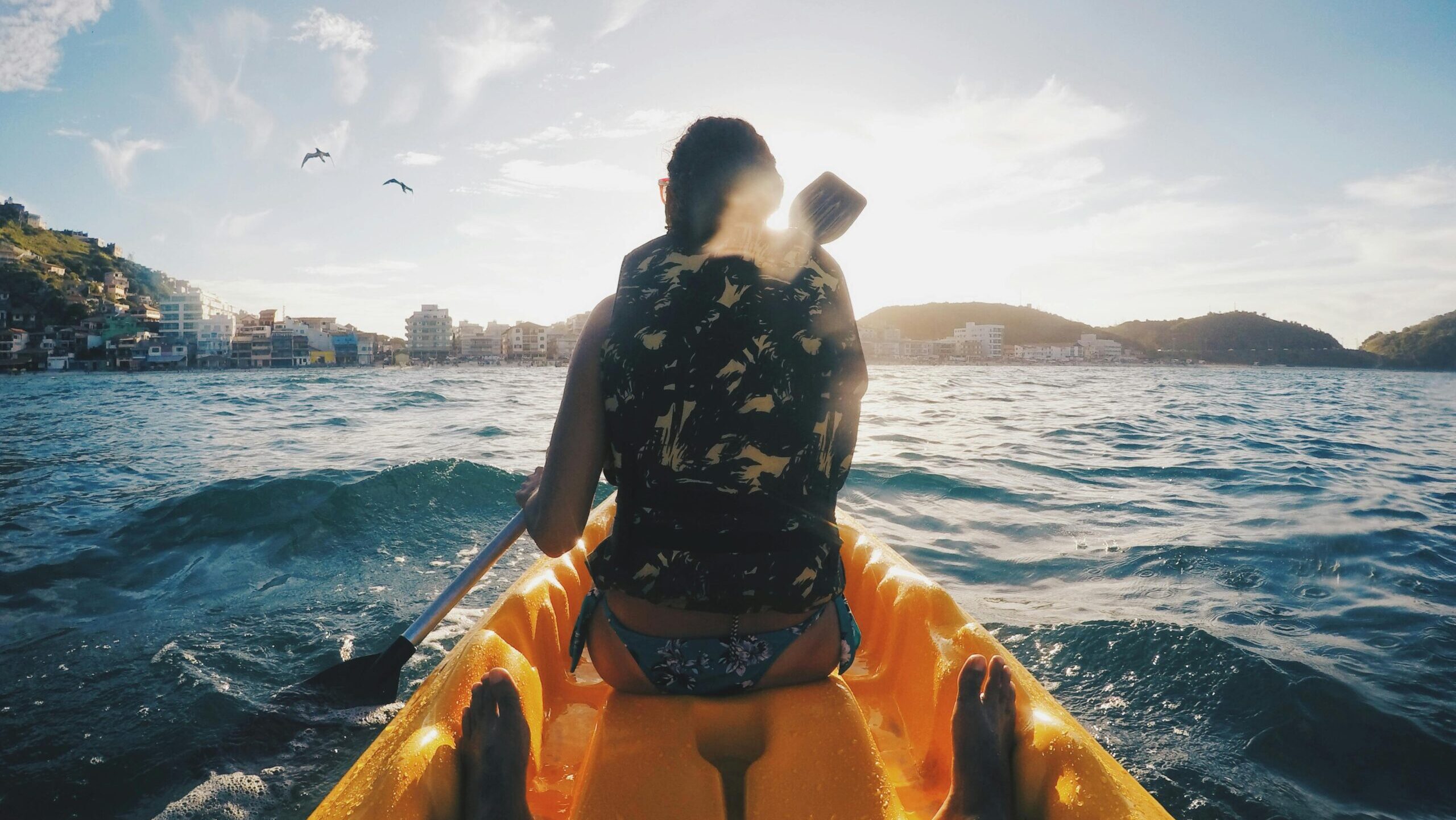 Experience the thrill of kayaking in Arraial do Cabo, Brazil with the sunlit waves and clear skies.